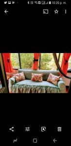 a picture of a couch in front of a window at Las Cabañas Castillos del Lago in Guatapé