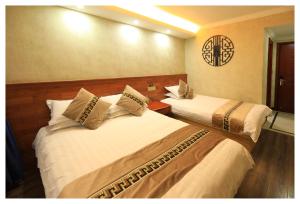 a hotel room with two beds and a clock on the wall at Xian Yan Inn in Yueqing
