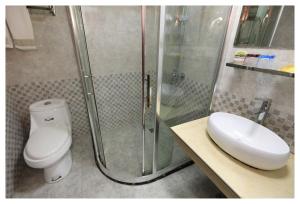 a bathroom with a shower and a toilet and a sink at Xian Yan Inn in Yueqing