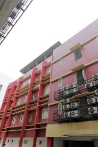 een rood gebouw met airconditioning op de balkons bij RedDoorz Plus near Galaxy Bekasi in Bekasi