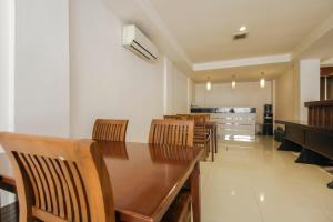 a dining room with a wooden table and chairs at RedDoorz Plus near Galaxy Bekasi in Bekasi