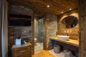 a bathroom with a sink and a stone wall at Boutique Lodge Spycher in Saas-Fee +55 photos