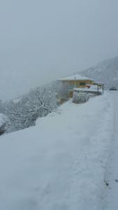 Résidence E CIME ASCO في Asco: ساحة مغطاة بالثلج مع منزل في الخلفية