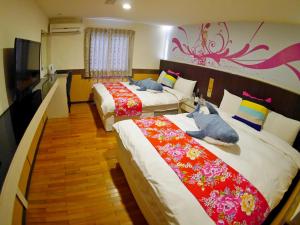 een hotelkamer met 2 bedden en een televisie bij Galaxy Hotel in Zhongli
