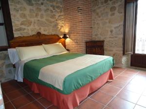 a bedroom with a large bed in a brick wall at Posada Puerta Grande in Candelario