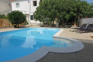 a large blue swimming pool in a yard at Stars Palace in Jezera