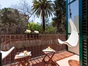 a patio with two chairs and two tables and a fence at Ecozentric in Barcelona