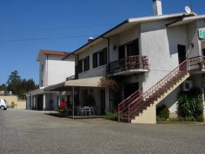 a white building with stairs and tables in front of it at Senhor dos Perdoes Alojamento Local in Ribeirão