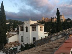 グラナダにあるCasa en el Albaicinの城を背景にした丘の上の古い建物