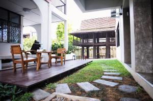 a patio with a table and chairs and a yard at Na BaanYa Chiang Mai in Chiang Mai