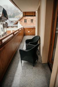 2 sillas sentadas en un balcón con vistas en Apartment Arnika Kranjska Gora, en Kranjska Gora