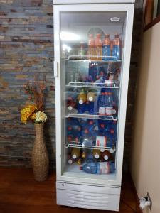 a refrigerator filled with lots of bottles of soda at Hospedaje klickmann in Temuco