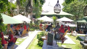 a group of people sitting at tables under umbrellas at Cordia Hotel Surabaya Airport - Hotel Dalam Bandara - Formerly Ibis Budget Surabaya Airport in Sidoarjo