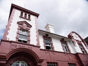 陶朗加Clarence Boutique Hotel的一座红色和白色的建筑,上面有时钟