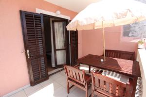 a table and chairs with an umbrella on a balcony at Apartments Alissa in Hvar