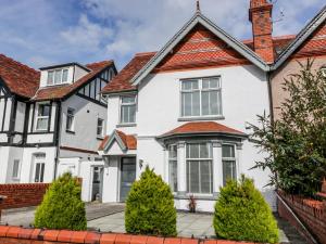 una casa blanca con techo rojo en Westpoint, en Llandudno