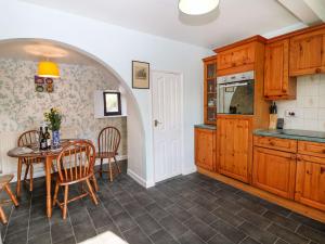 a kitchen with a table and a dining room at Dove Cottage in Clowne
