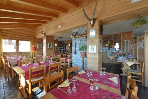 une salle à manger avec des tables et des chaises dans un restaurant dans l'établissement Hotel Maisonnette, à Torgnon