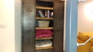 a wooden cabinet with towels in a room at 10 Via Giuseppe Sirtori in Milan