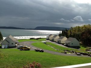 a group of houses on a road next to the ocean at Lantern Hill & Hollow in Ingonish Beach