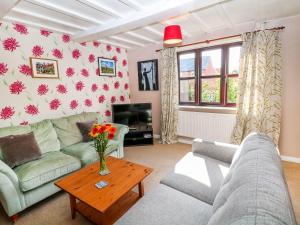 a living room with a couch and a table at Dove Cottage in Clowne