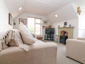a living room with a couch and a fireplace at The Watch in Porthcurno