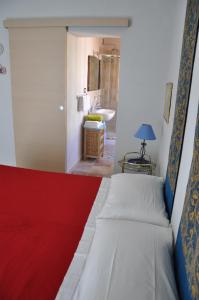 - une chambre avec un lit et une salle de bains pourvue d'un lavabo dans l'établissement Pà Blanc B&B, à Alghero