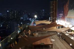 grupa ludzi siedzących w nocy na pokładzie w obiekcie Handpicked Hotel & Collections w Seulu