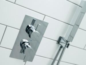 a shower head on a white tile wall at Teviot Cottage in Corbridge +27 photos