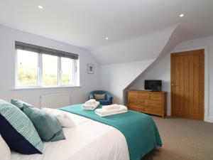 a bedroom with a bed with two towels on it at Myles View in Penzance