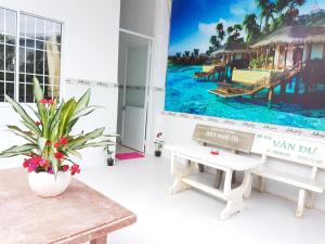 a room with a bench and a picture of a resort at Song Ngoc Guesthouse in Phú Quốc