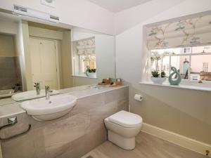 a bathroom with a sink and a toilet and a mirror at Castle Hill in Bakewell +35 photos
