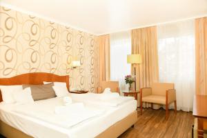 - une chambre avec un grand lit blanc dans l'établissement Apart Hotel Haveltreff, à Caputh