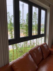 un canapé installé devant une grande fenêtre dans l'établissement HOÀNG SA HOTEL, à Cam Ranh