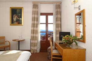 a hotel room with a desk and a bedroom at Boutique Hotel Parnassia in Arachova