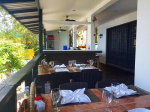 um restaurante com mesas e cadeiras com copos e guardanapos em Blue Ribbon Dive Resort em Mabini
