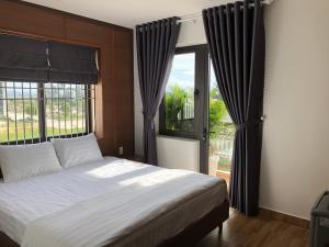 a bedroom with a bed and a large window at HOÀNG SA HOTEL in Cam Ranh