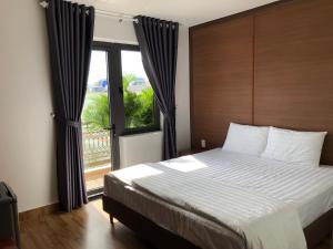 um quarto com uma cama grande e uma janela grande em HOÀNG SA HOTEL em Cam Ranh
