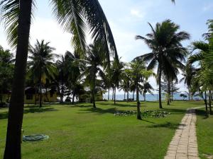 un parc avec des palmiers et un chemin dans l'établissement Malai-Asia Resort, à Thap Sakae