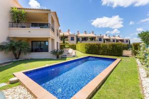 a villa with a swimming pool in front of a house at Mar da Luz in Luz
