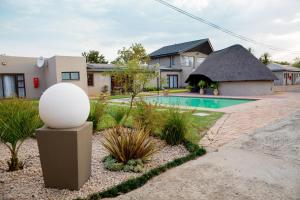 a house with a yard with a pool at Appledew Guesthouse in Standerton
