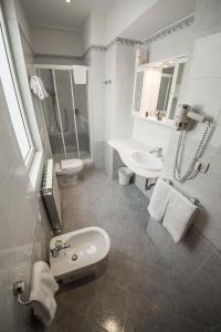 een witte badkamer met een wastafel en een toilet bij Residence Victoria in Trieste