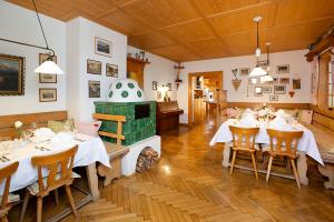a dining room with tables and a green stove at Hotel Wiedemann in Füssen