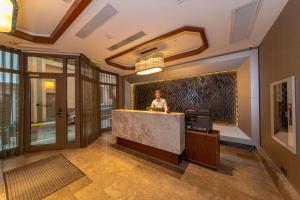 a man standing at a counter in a lobby at Feri Suites in Istanbul