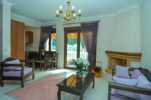 a living room with a fireplace and a dining room at Kerveli Luxury Villa in Kerveli