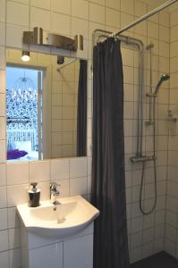 baño con lavabo y cortina de ducha en Pensionat Prästgården, en Töreboda
