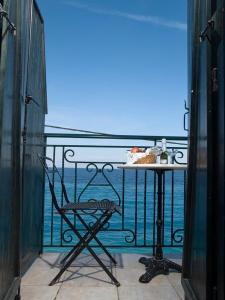 una mesa y una silla en un balcón con vistas al océano en Meliti Guesthouse, en Akráta