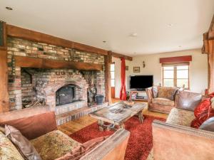 a living room with a large brick fireplace at Derrywater House in Aughrim