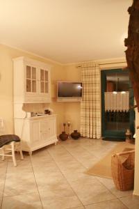 a living room with a television and a tiled floor at "Steuerbord" by Ferienhaus Strandgut in Born