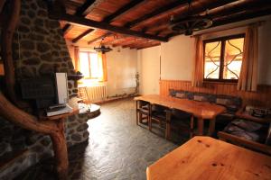 a living room with a wooden table and a tv at Belcheva kashta in Banya